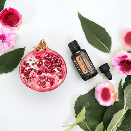doTERRA Pomegranate essential oil bottle with a pomegranate, leaves, and flowers on a white background