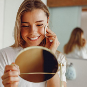 Woman applying makeup in front of a mirror