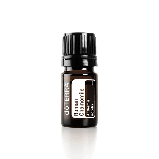 A small, dark-colored bottle of doTERRA Roman Chamomile essential oil with a white label displaying the product name and doTERRA branding.