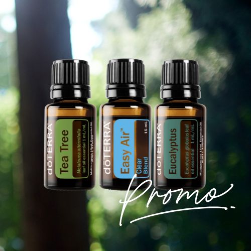 Three doTERRA essential oil bottles with a blurred natural background