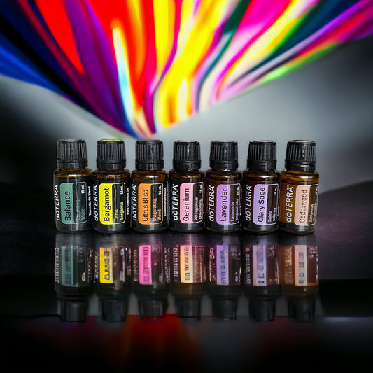 A selection of seven doTerra essential oil bottles, each representing a different color and scent, arranged in a row with a vibrant, colorful background.