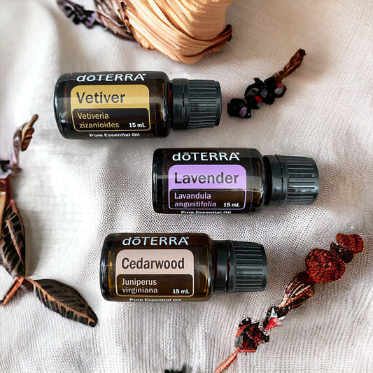 doterra vetiver, doterra lavender and doterra cedarwood essential oils laying on a linen cloth surrounded by natural elements.