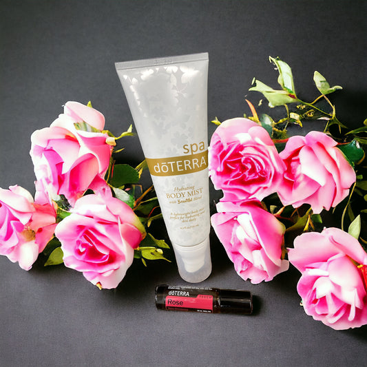 doterra rose touch and doterra hydrating mist on against a grey back drop with pink flowers.