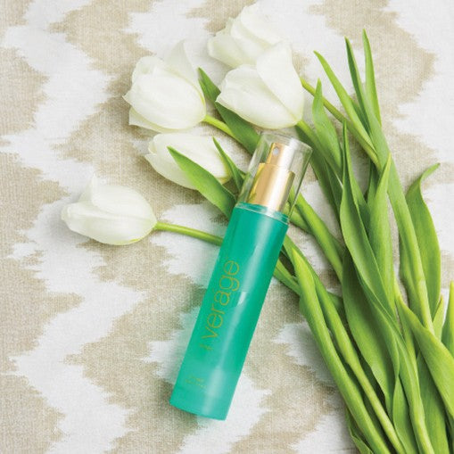 Green skincare serum bottle labeled verage toner with tulips on a textured fabric background
